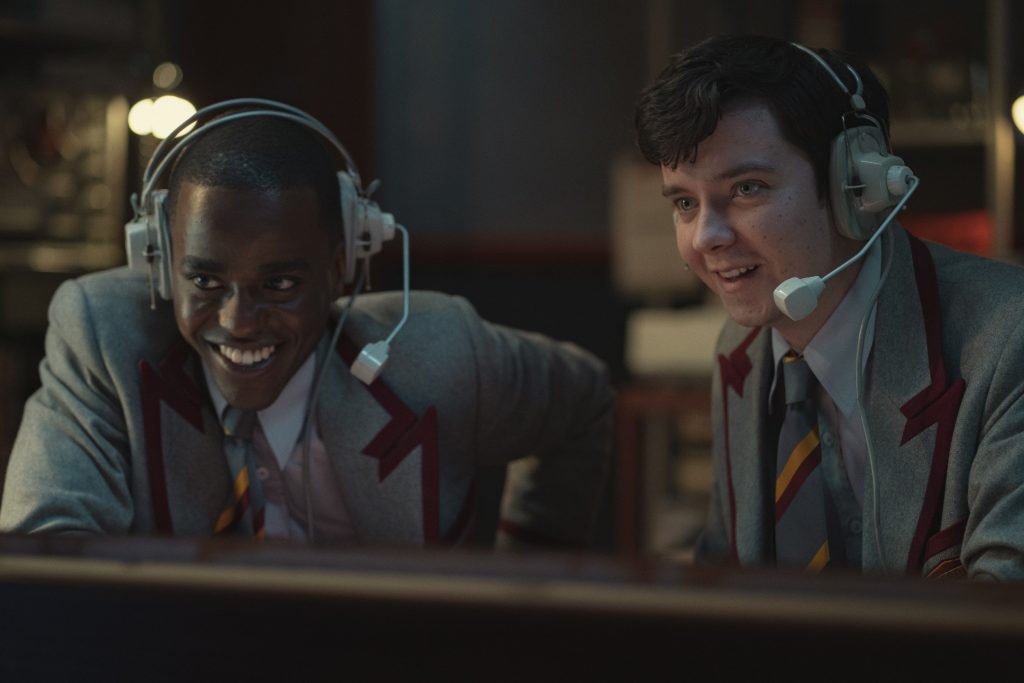 Otis et Eric à la régie pendant le concert de l'orchestre du lycée lors de la journée portes ouvertes accueillant la presse - ©Netflix, 2021